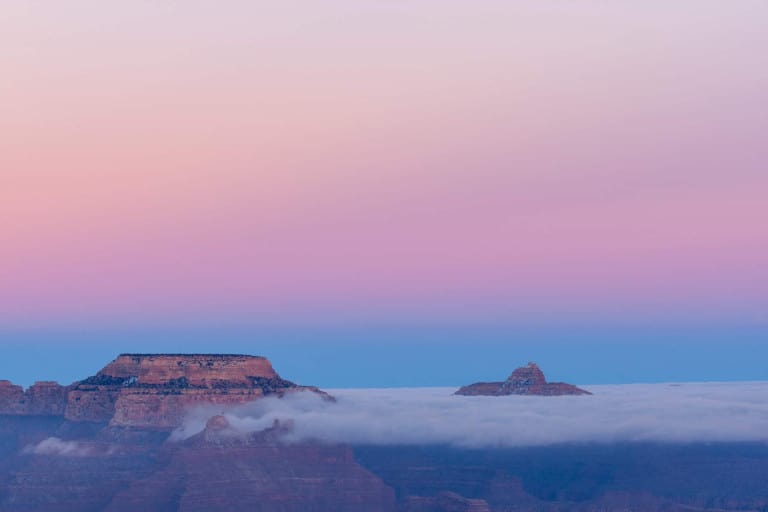 the grand canyon south rim at sunset with low hanging clouds