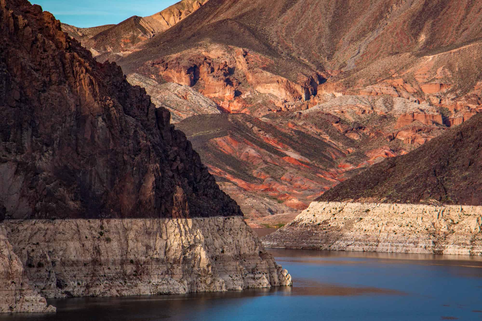 the rocky landscape around lake mead is beautiful with its multiple colored layers and calm waters