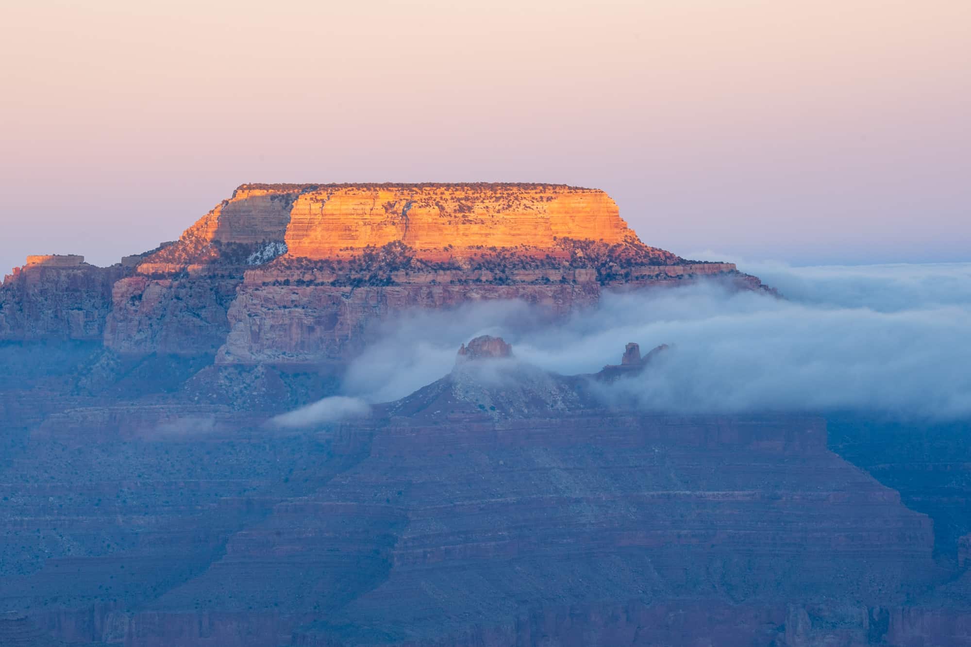 the grand canyon at sunset with some low lying clouds