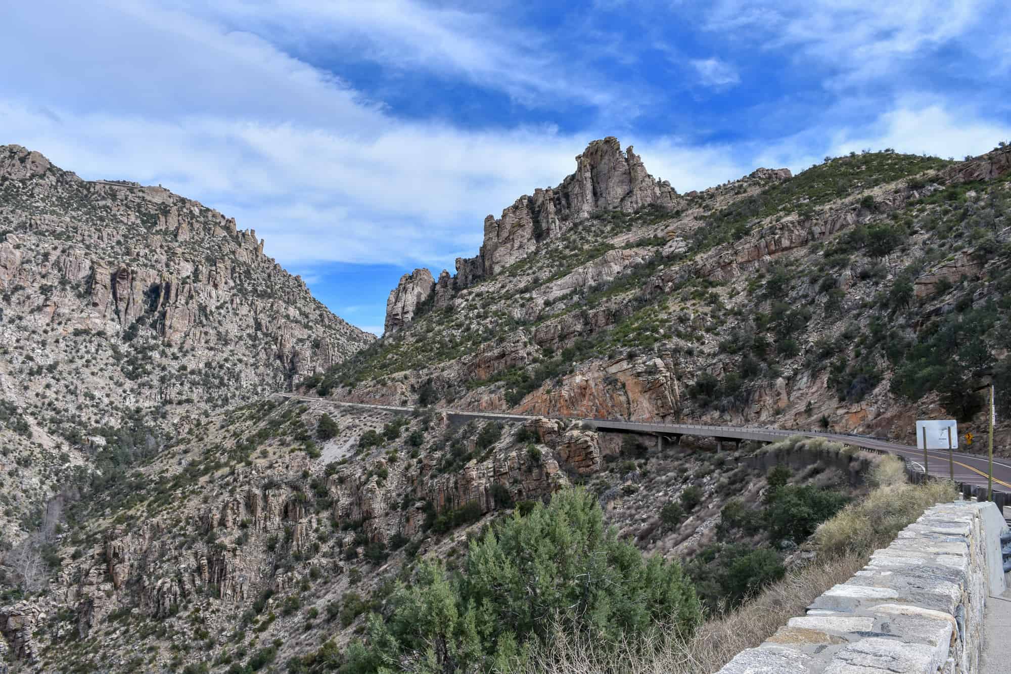 the scenic drive at mt lemmon, photo shows the road heading between two mountains in the distance