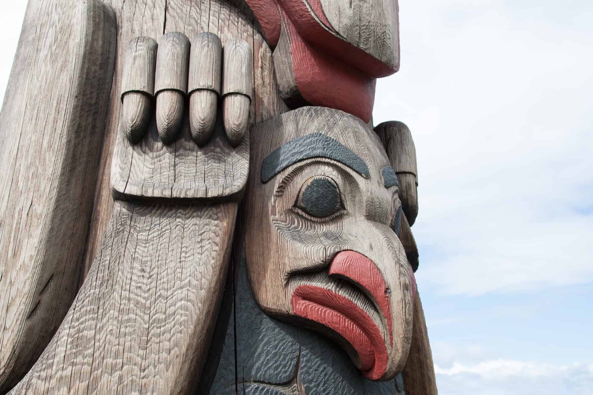 close-up of one of the totem poles that adorn seattle, this one is a bird like creature with a long beak