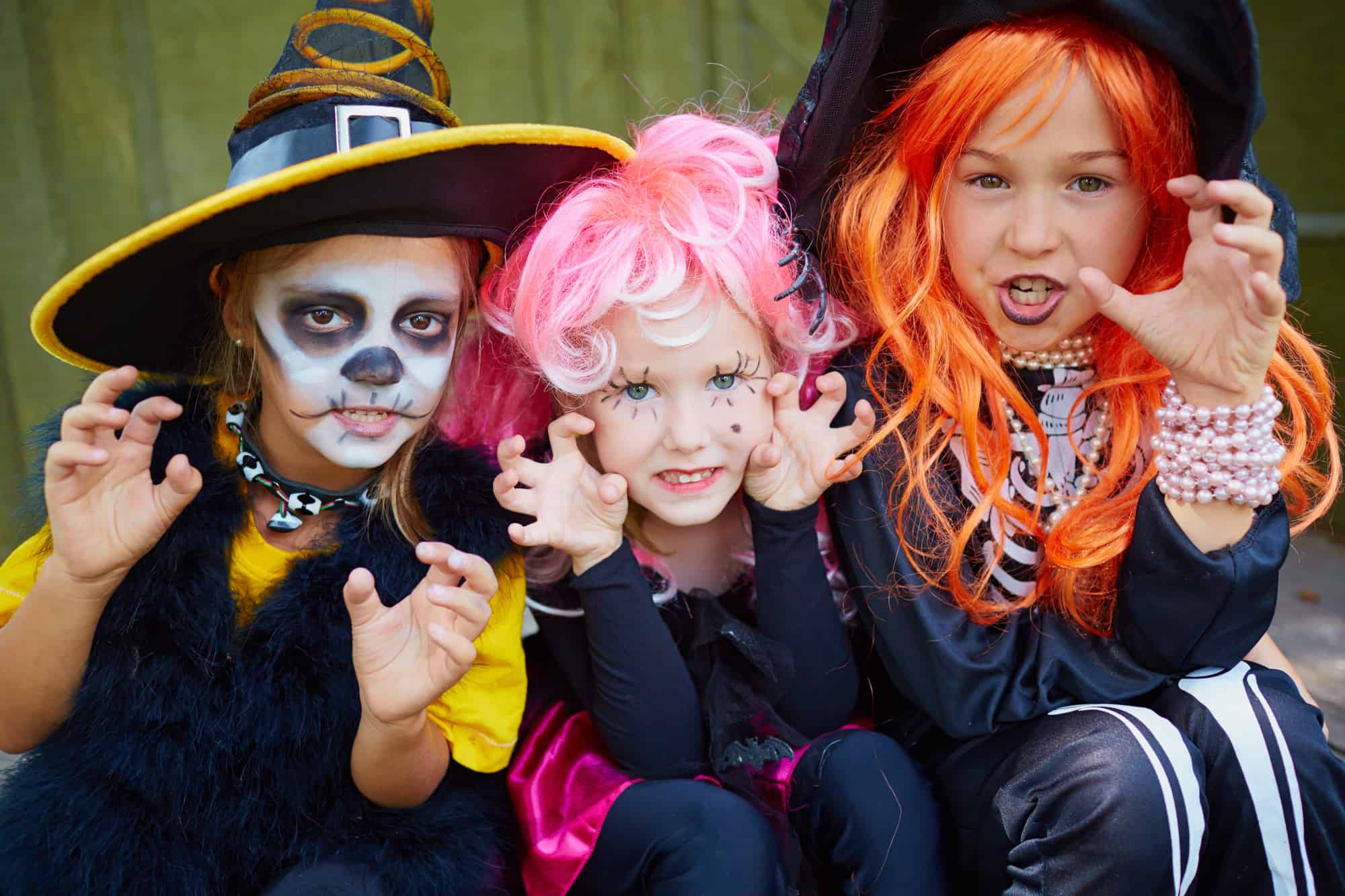 3 small girls dress for witches and skeletons for halloween