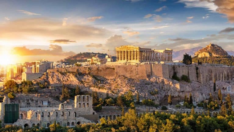 A landscape photo of Athens Greece at sunrise with beautiful light shining on the ruins