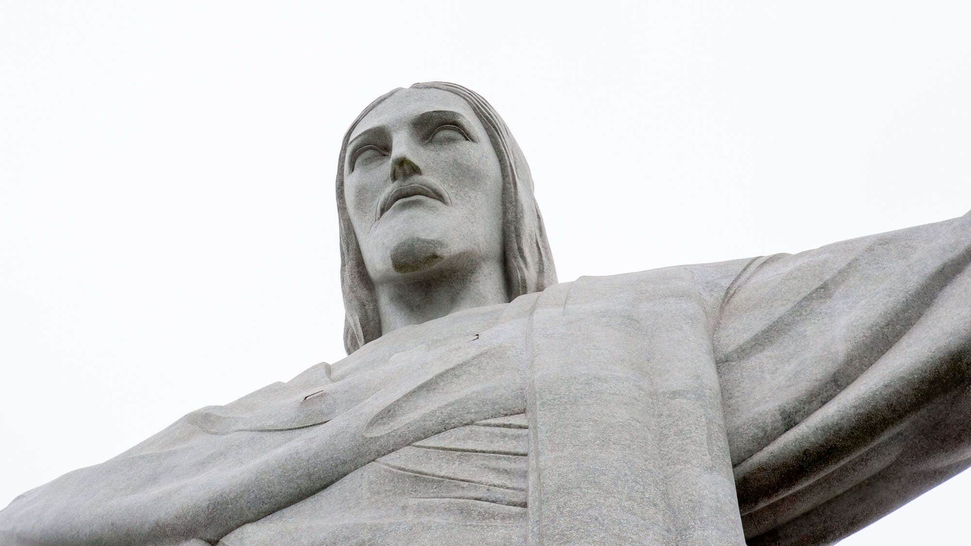 A close-up of the iconic Christ the Redeemer statue in Rio de Janeiro, Brazil, with its arms outstretched and a serene expression.