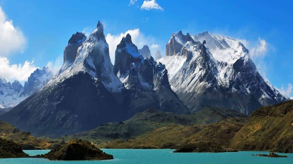Majestic snow-covered peaks of the Cordillera del Paine with a turquoise lake in the foreground in Torres del Paine National Park, Chile.