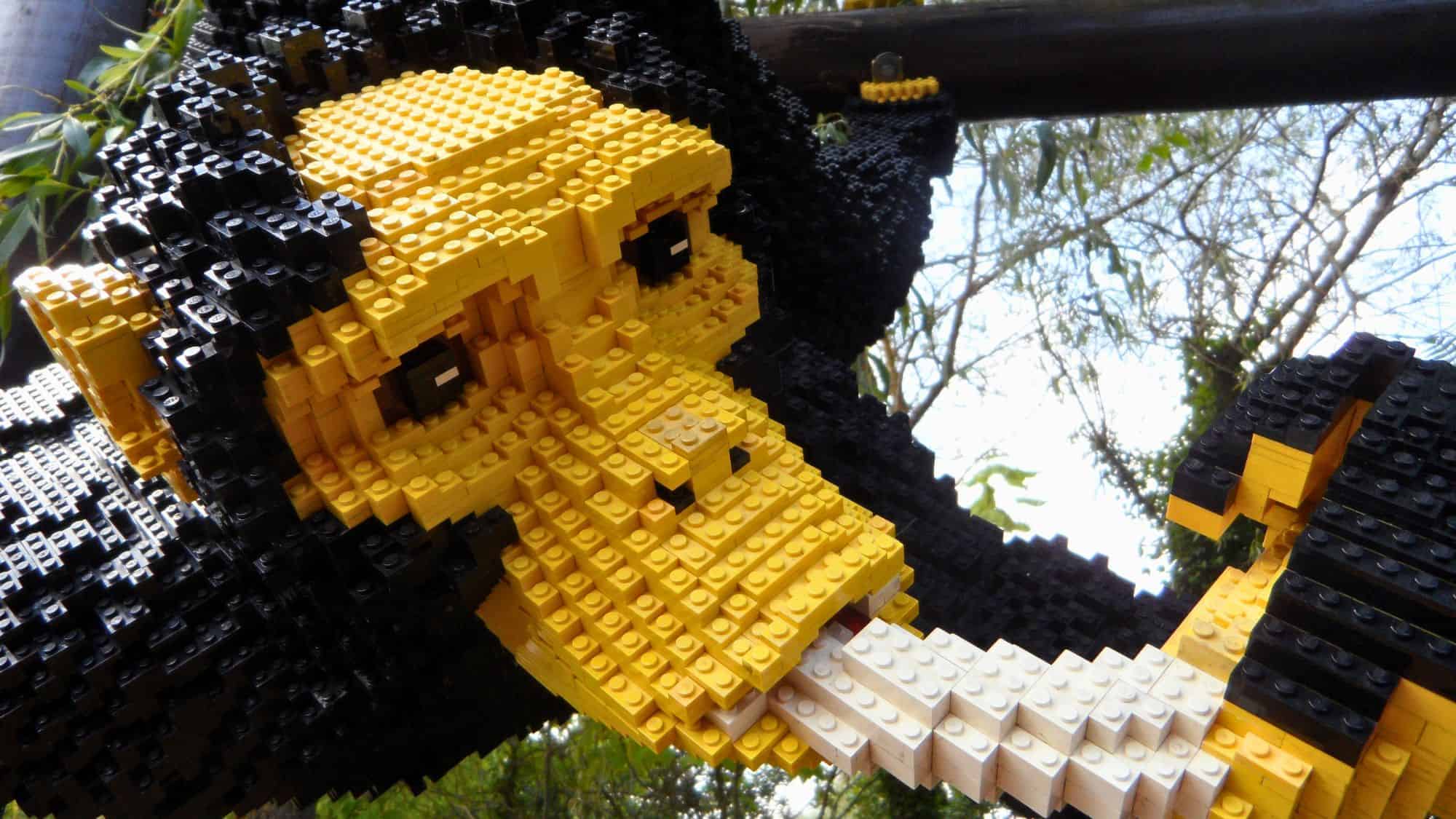 A close-up of a chimpanzee made entirely of LEGO bricks at Legoland. The yellow and black brickwork creates a detailed and lifelike representation.