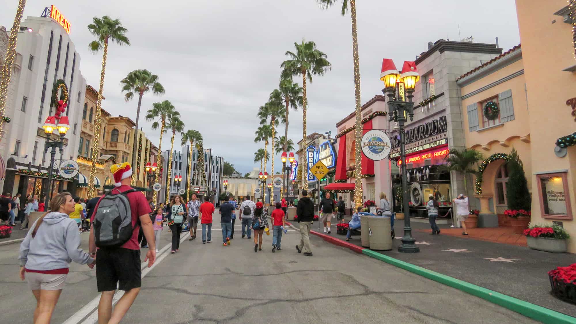 A view of the main strip of Universal Studios with buildings along both sides and pedestrians wandering around. 