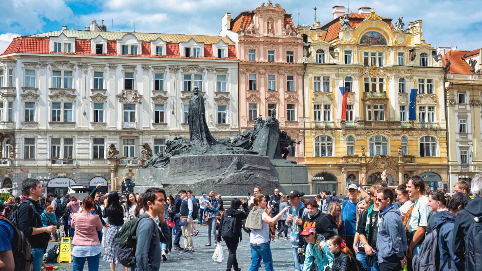 Prague, Czech Republic - May 25, 2019: Tourists exploring Old Town Square in Prague, taking pictures of the impressive Jan Hus monument