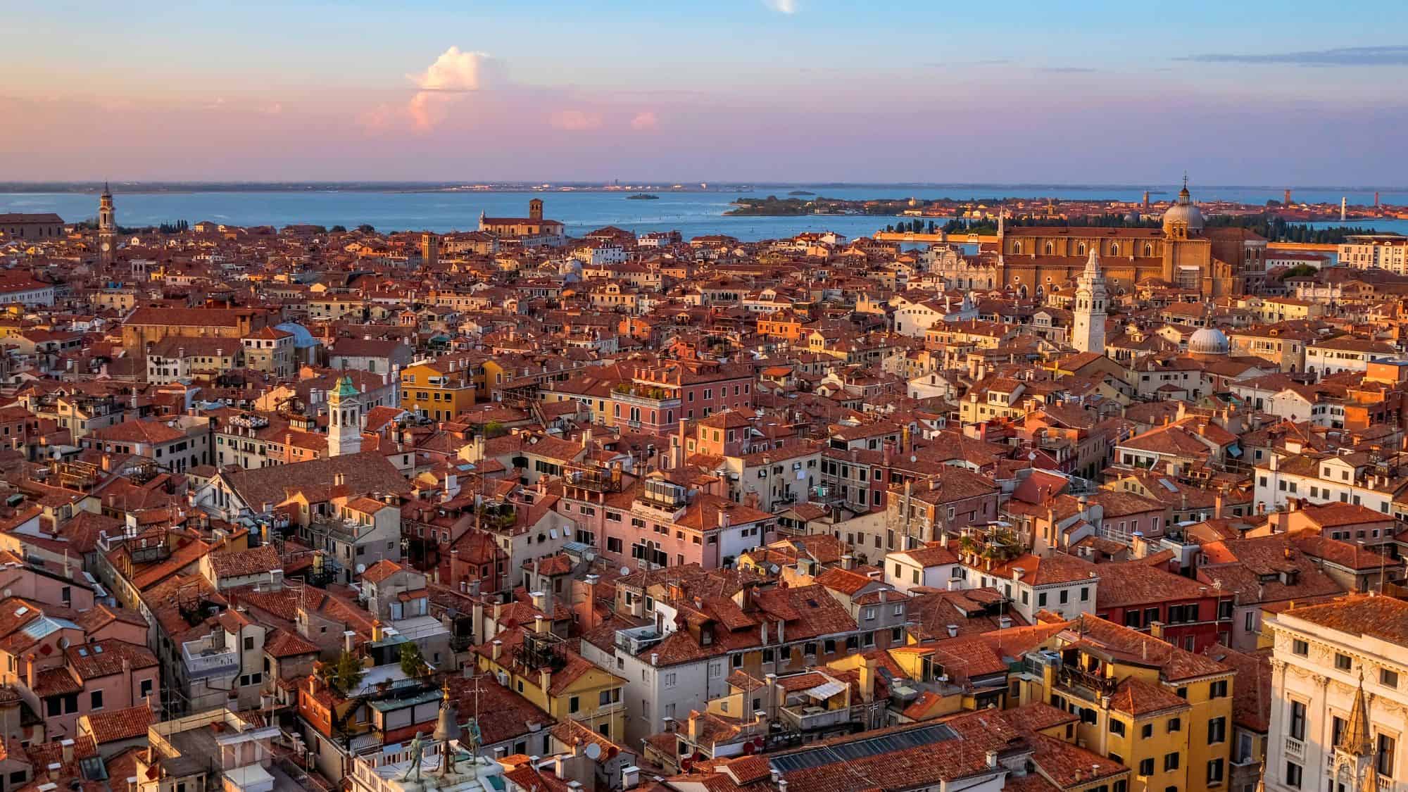 VENICE, VENETO/ITALY – SEPTEMBER 21 2020: Aerial Panoramic View of Venice and the Lagoon from the top of Campanile di San Marco in Saint Mark Square - A Beautiful Sea of Red Roof Tiled Houses