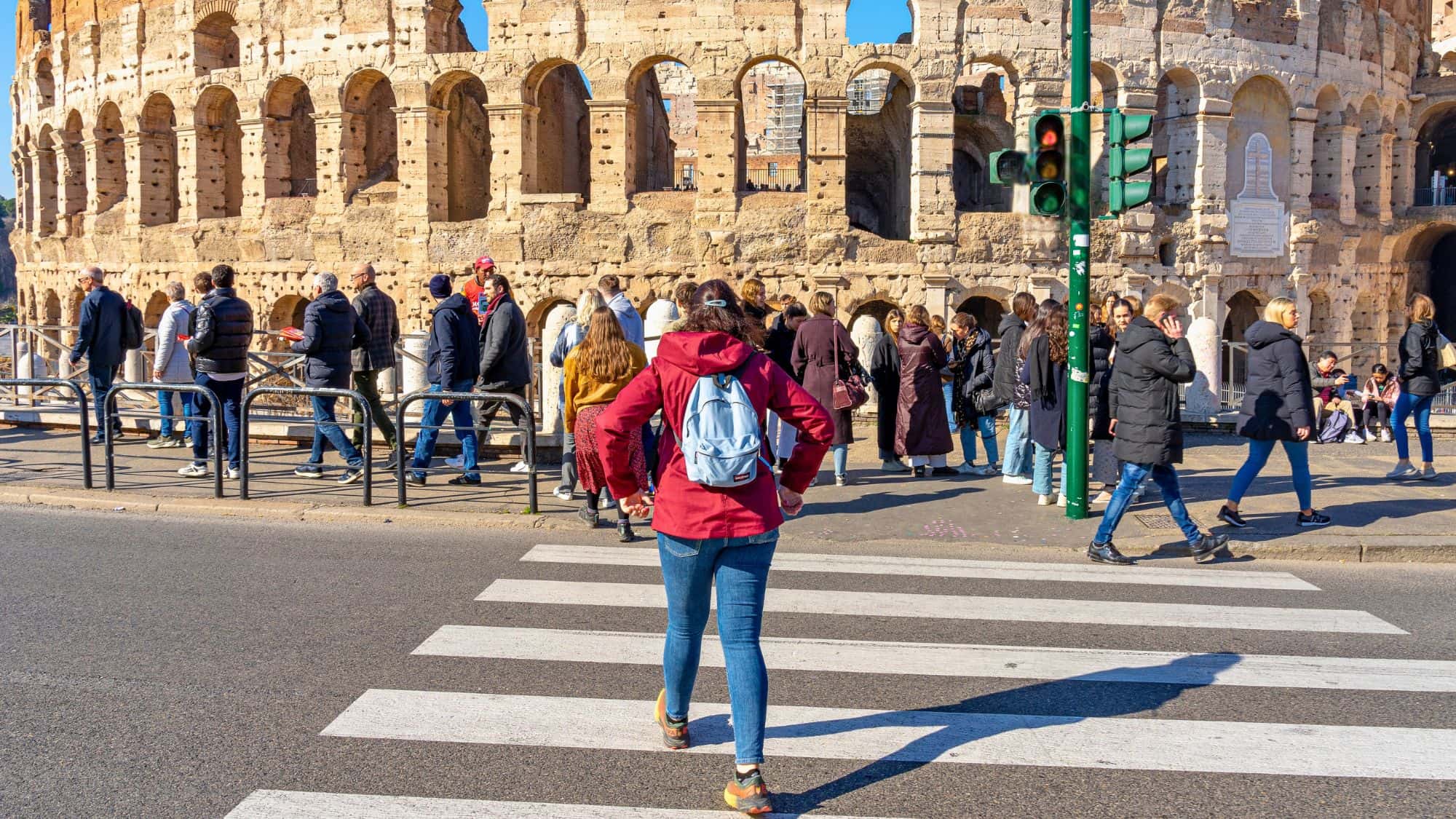 people crossing the road on the crosswalk next to the coliseum in Rome, Italy.11-11-2023