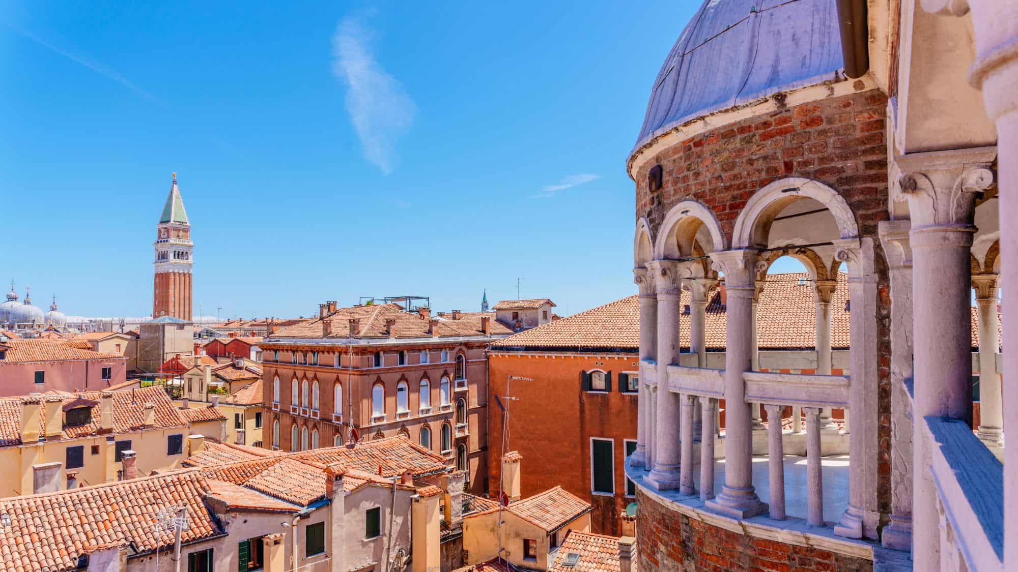 A close-up of the famous spiral staircase, Scala Contarini del Bovolo, with its graceful arches and red-brick walls overlooking Venice’s rooftops.