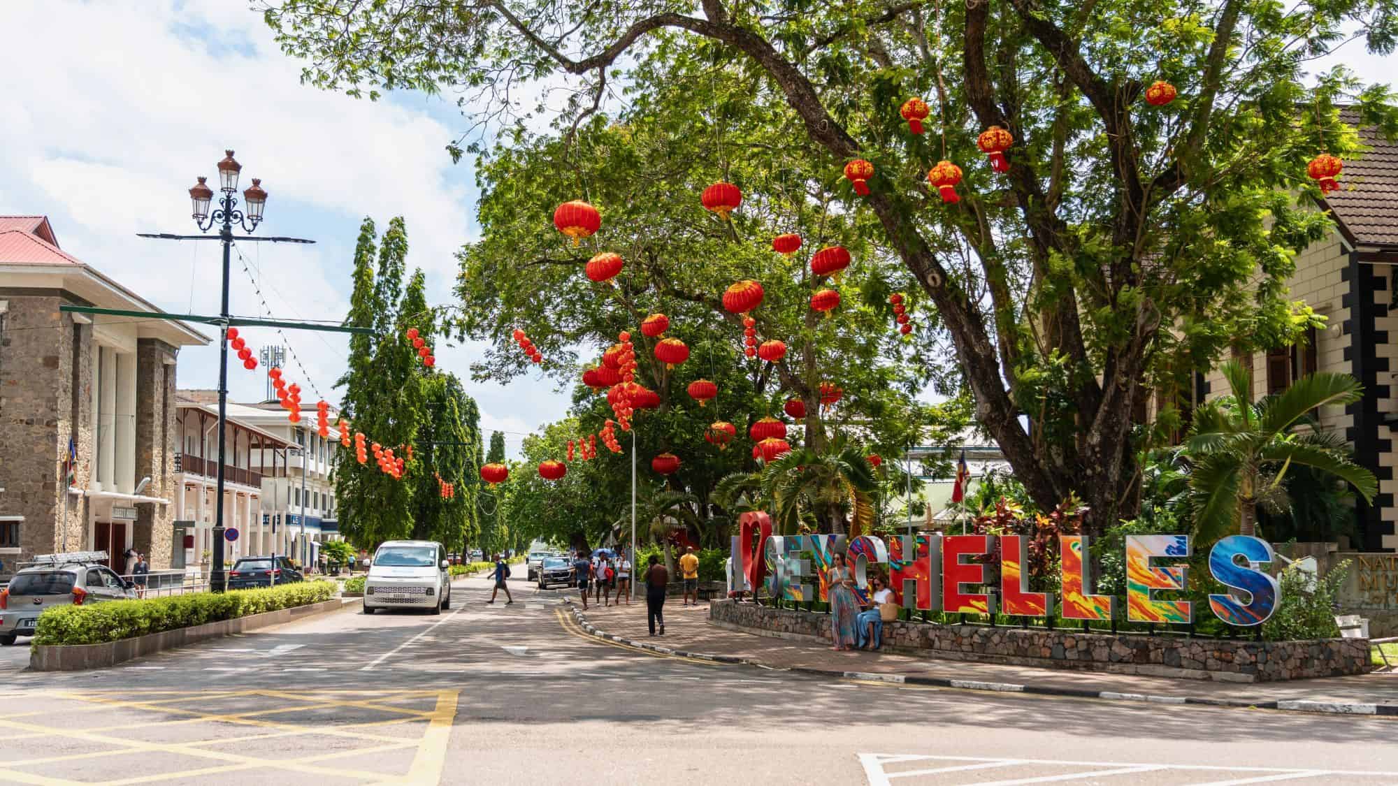 Victoria, Seychelles, January 31, 2025: Colorful Seychelles sign in Victoria with tourists and red lantern decorations editorial image