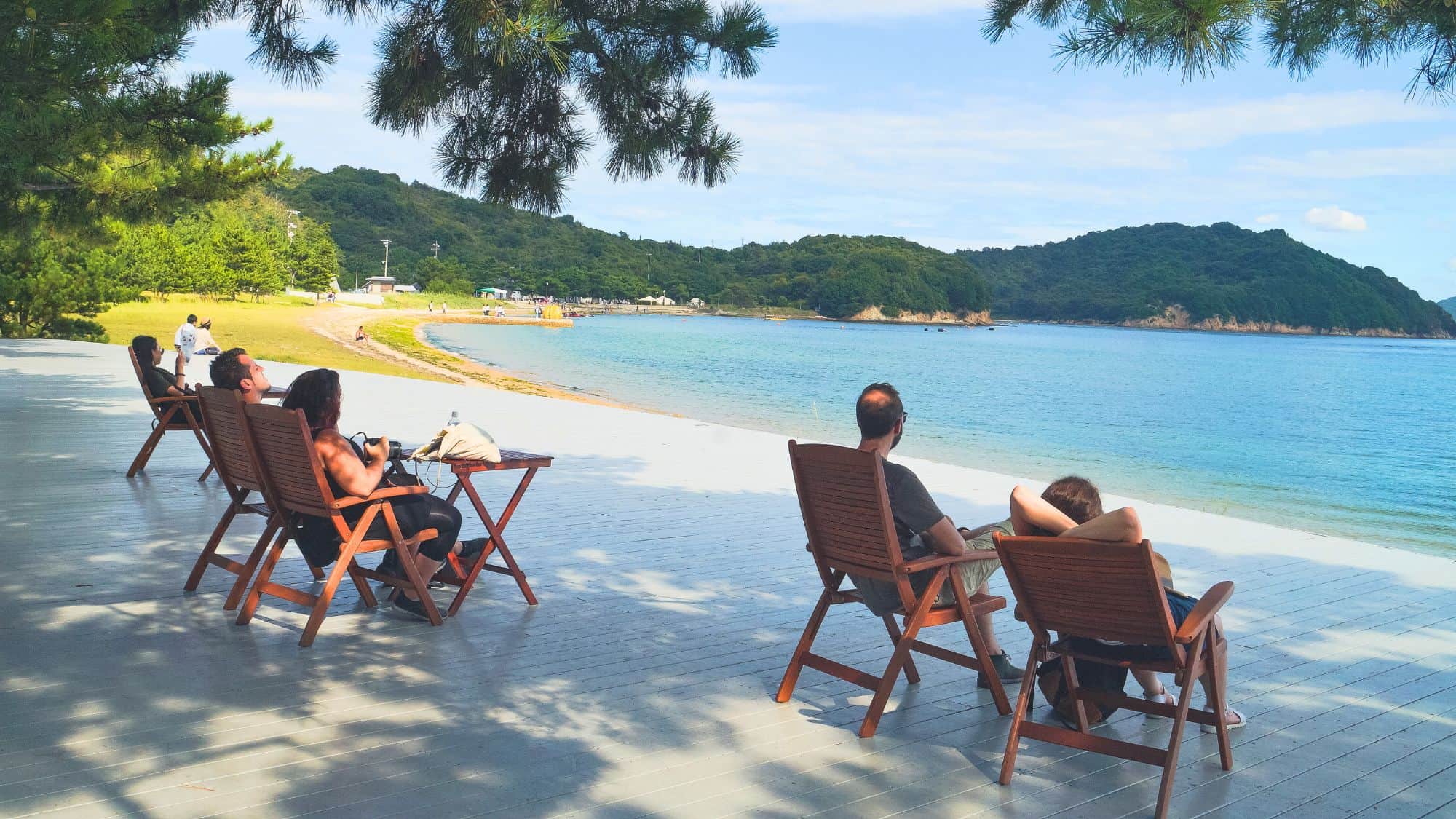 Naoshima, Japan - Aug 7th, 2017:People lie down on the deck chair enjoying the view of sea. It's their summer travel on Naoshima Island, Japan.