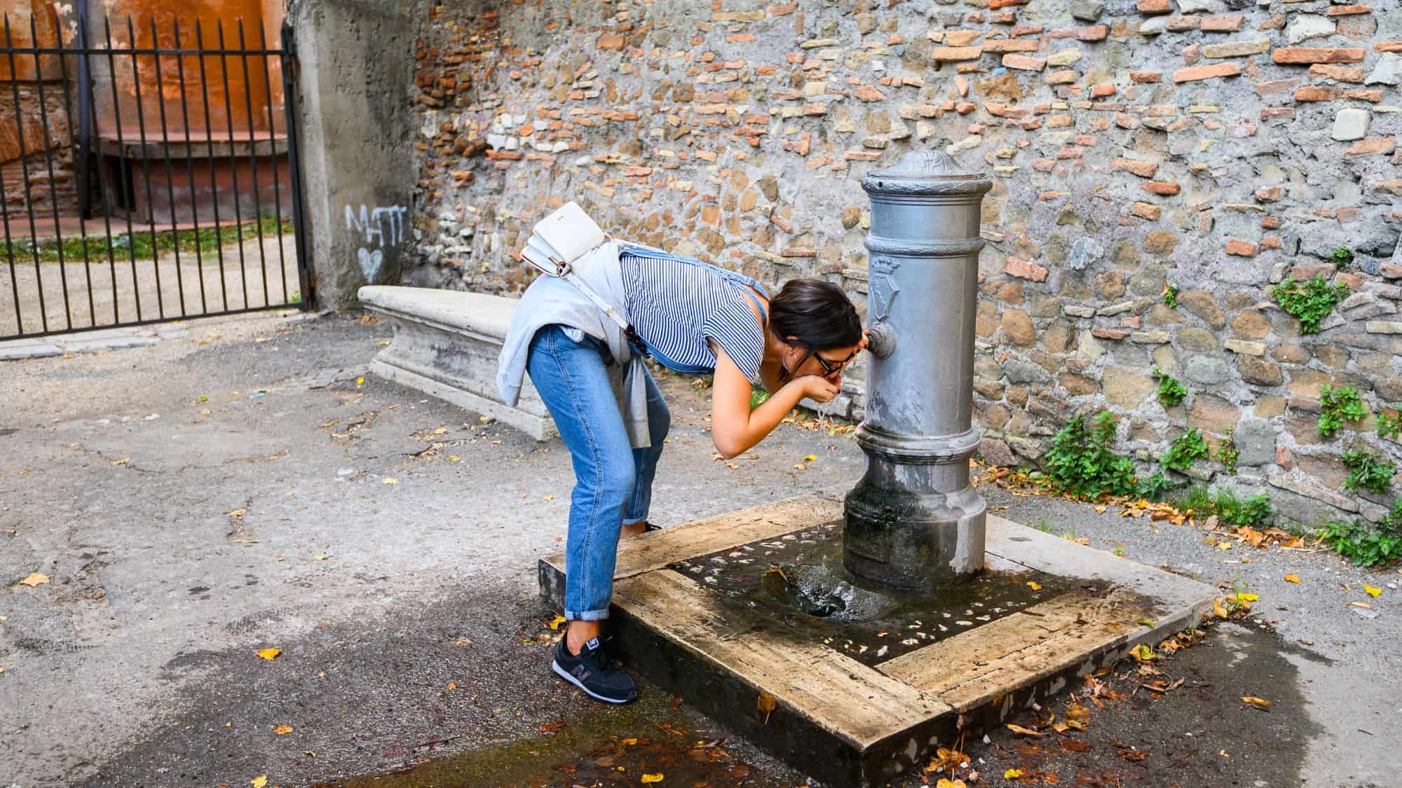 10.10.2019 Rome, Italy. Girl drinking from street drinking fountain