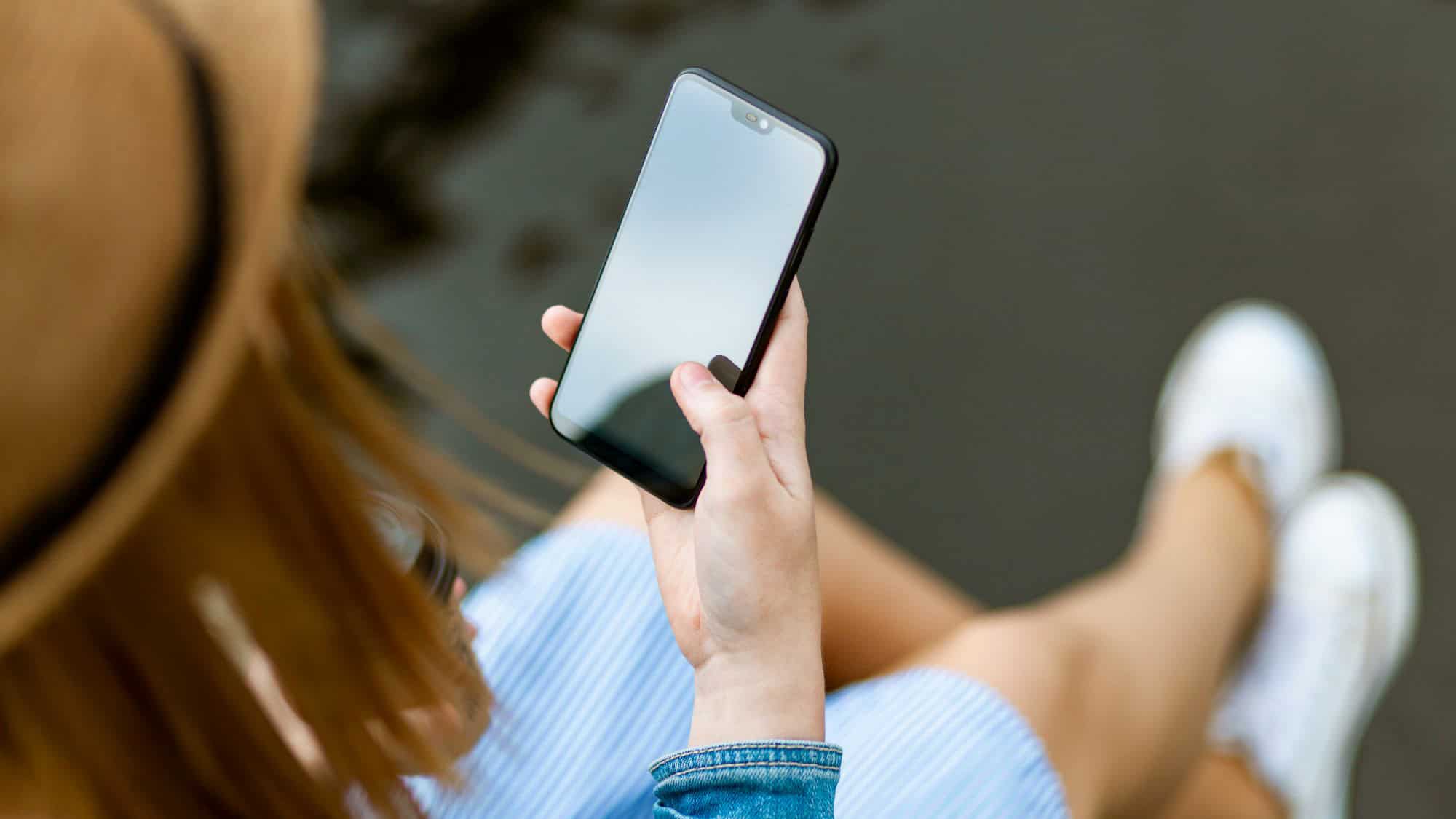 A woman seated in an airplane chats on her phone, visibly animated, while surrounding passengers show signs of irritation—highlighting an in-flight social faux pas.
