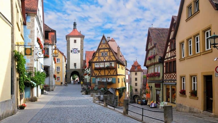 The iconic cobblestone street of Rothenburg curves past timbered houses and leads to the medieval Siebers Tower.