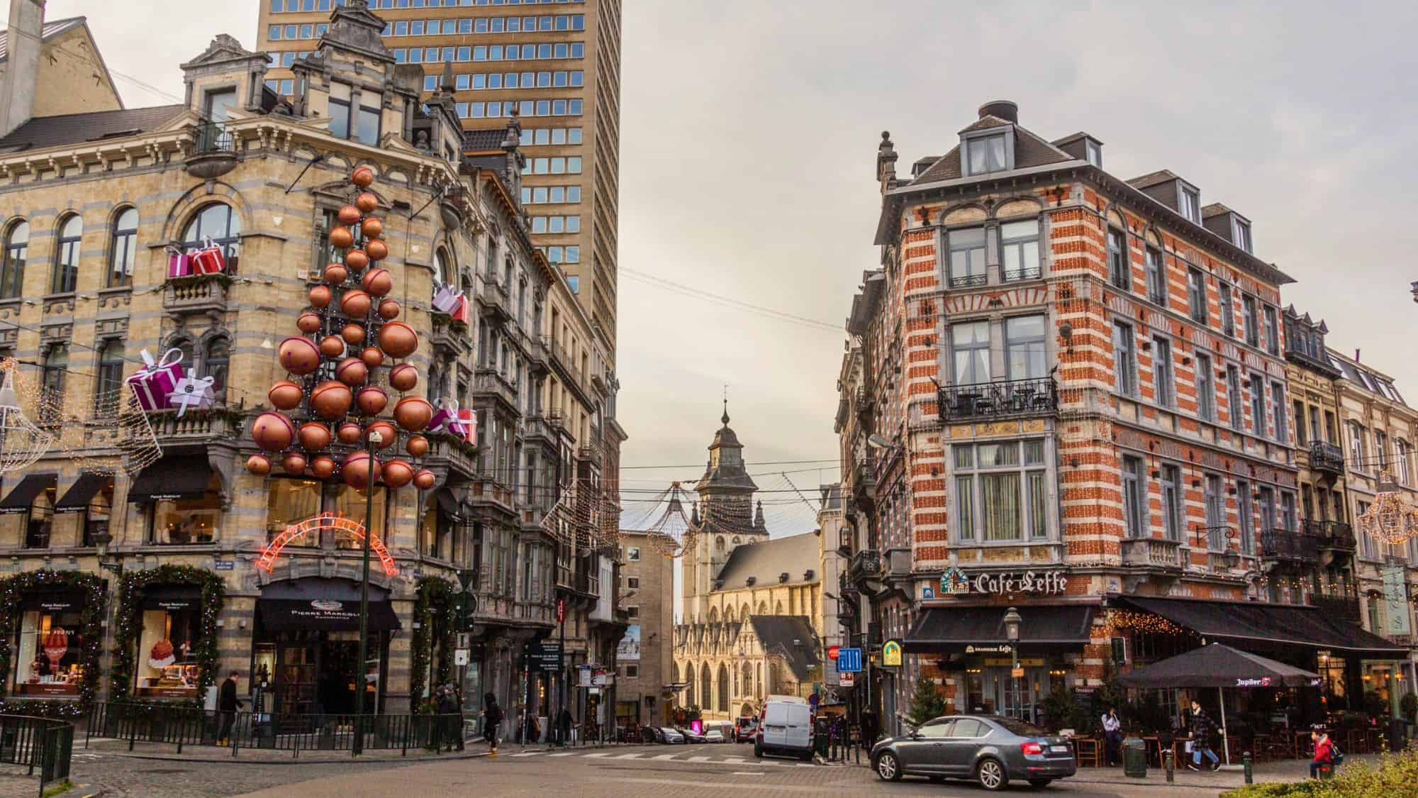 Antwerp’s streets are adorned with festive holiday decorations, including a modern ornament tree and gift displays on historic buildings.